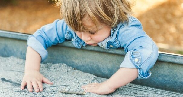 fëmija luan në sandbox dhe infektohet me krimba